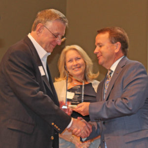 James Costner accepts the Distinguished Alumnus Award from WBC president Dr. Tom Jones while Costner's wife, Mary, looks on.
